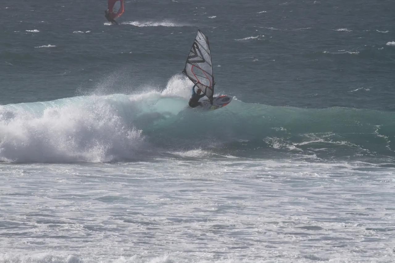 Windsurfer op een groene golf