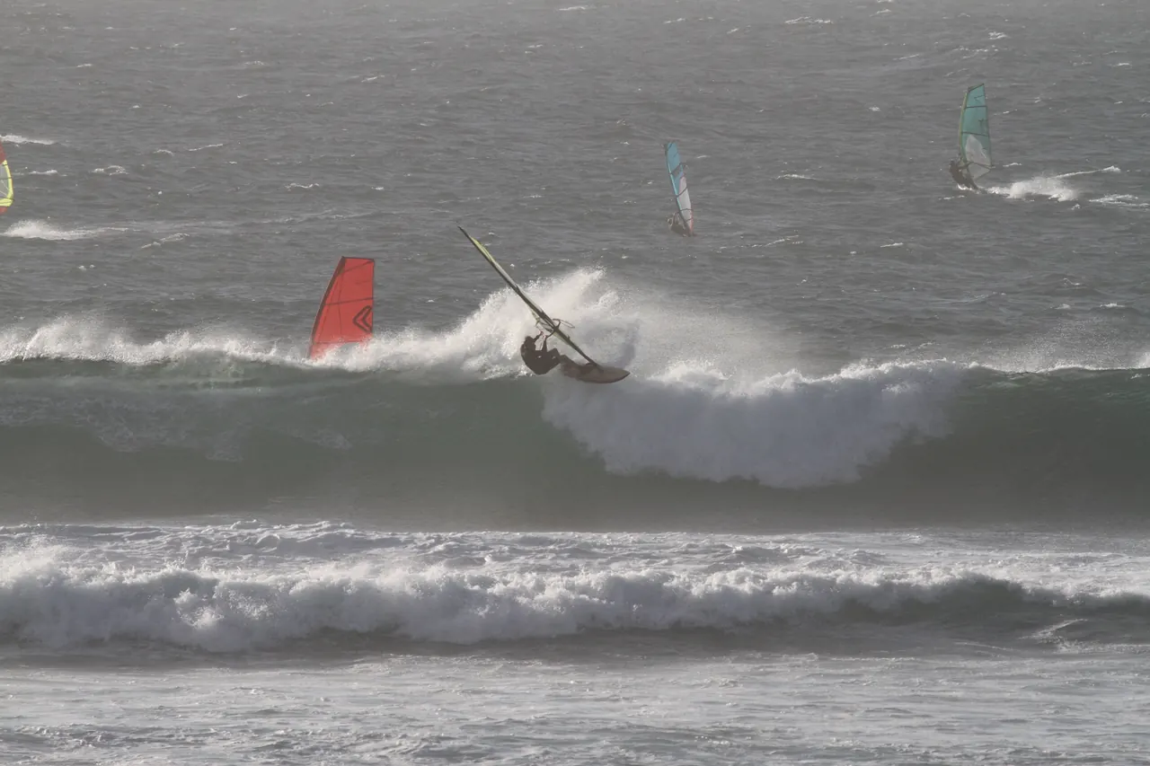 Windsurfer slaat spray van een golf