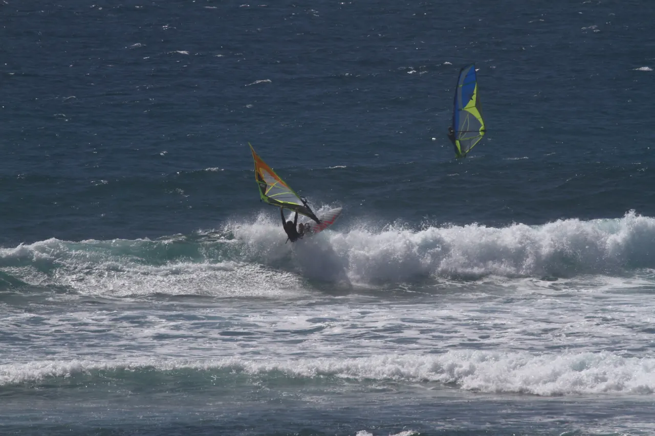 Twee windsurfers in de golven