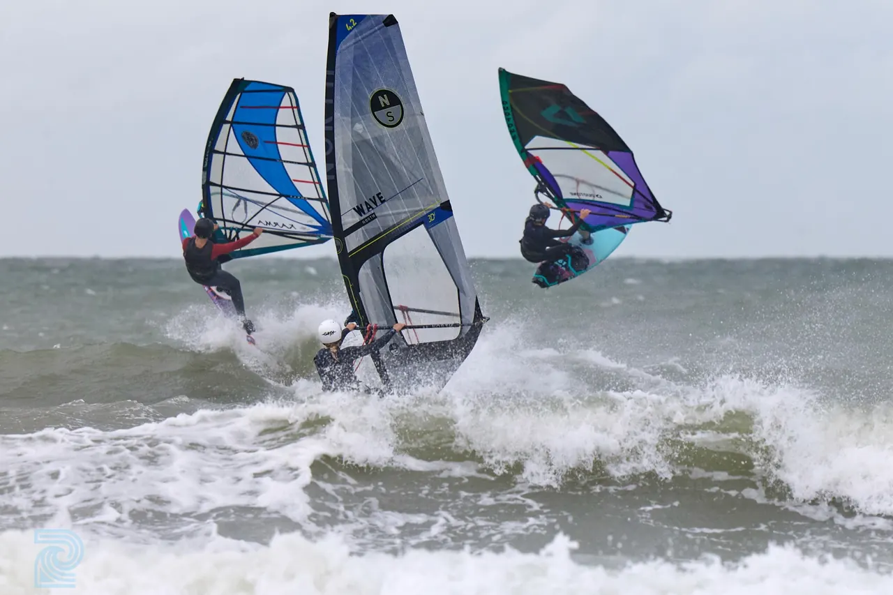 Jonge windsurfers in de golven