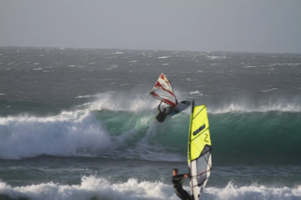 Twee windsurfers in de golven