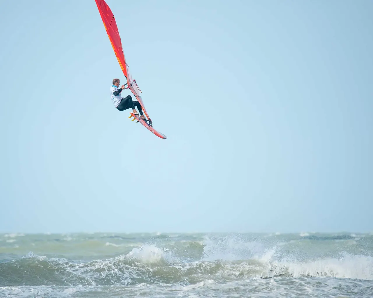 Windsurfer in de lucht boven de golven
