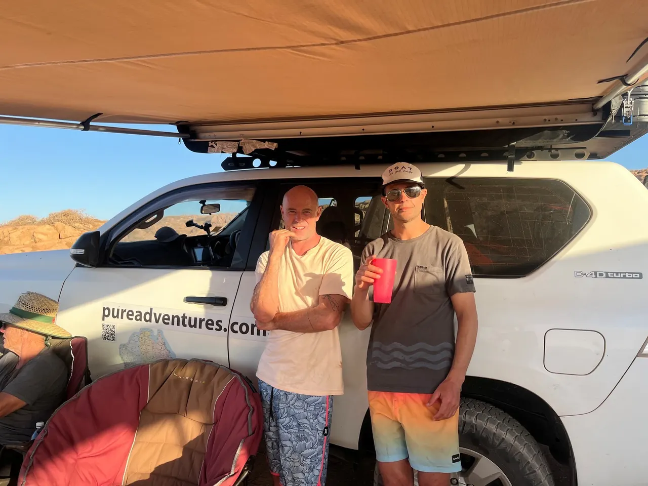 Twee crewleden aan de 4x4 van Pure Adventures
